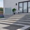 greyed nickel modern stone steps creating a short stair across the entire width of a back porch.