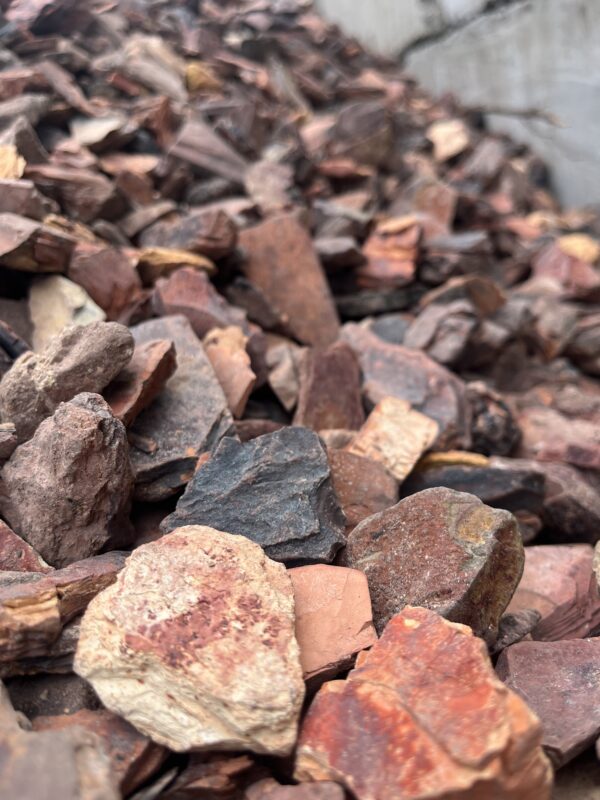 Uneven stones of reddish colors varying from light pink to very dark grey.